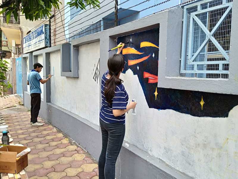 Arushi Das completing her portion of the mural